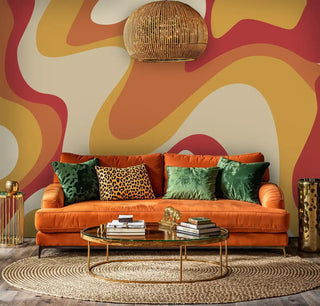 Abstract flowing wallpaper in red and orange hues with luxury orange velvet sofa and brass accents