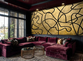 Abstract interlocking lines wall mural in gold and black, shown in luxury lounge with burgundy velvet seating