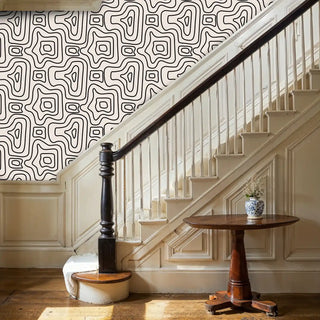 Abstract maze wallpaper in neutral tones displayed in elegant hallway with curved staircase