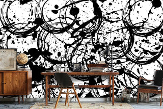 Abstract paint splash wallpaper with black brushstrokes and splatters on white, shown in home office with wooden desk