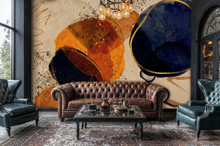 Abstract wall mural with gold shapes, navy and orange, shown with tufted chesterfield sofa