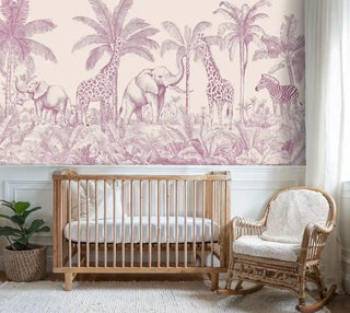 African safari wallpaper with pink elephants and giraffes among palm trees in elegant nursery with wooden crib and wicker chair