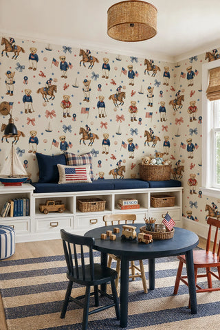 Americana teddy bear wallpaper with gingham bows, lobsters, and stars in navy and red, in a playroom with built-in bench