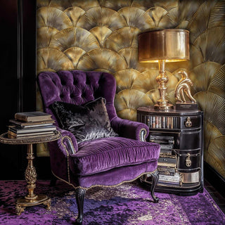 Art Deco fan wallpaper in gold tones shown in elegant reading nook with purple velvet armchair