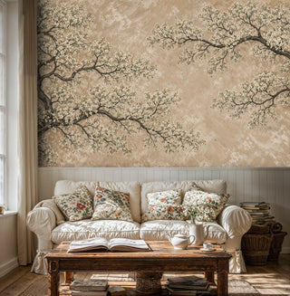 Beige cherry blossom wall mural with gnarled branches, displayed in cozy cottage living room with floral cushions