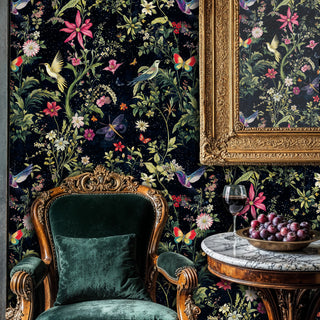 Bird and butterfly wallpaper on navy background with pink florals, in luxury sitting room with ornate green armchair