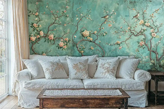 Birds and blossoms wall mural in teal and coral, featured in cozy living room with linen sofa