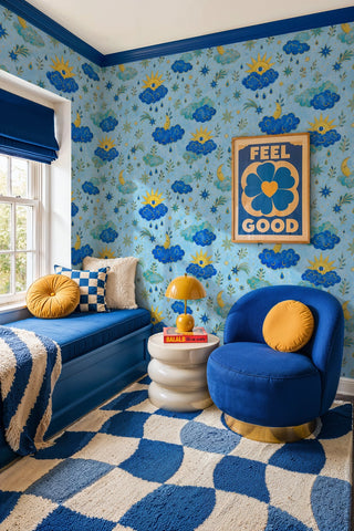 Blue and gold celestial cloud wallpaper with stars and raindrops in a cozy nook with checkered rug and framed art