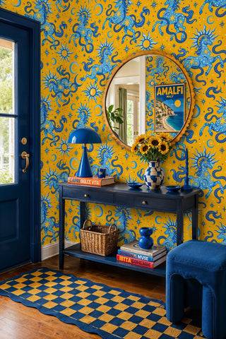 Blue and yellow celestial horse wallpaper with stars and moons, in an entryway with round gold mirror and console