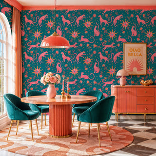 Bold leopard and sun motif wallpaper in pink and teal, in a dining room with checkered floor and teal chairs