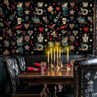 Bold tattoo-inspired wallpaper with skulls and serpents, featured in dining room with leather chairs
