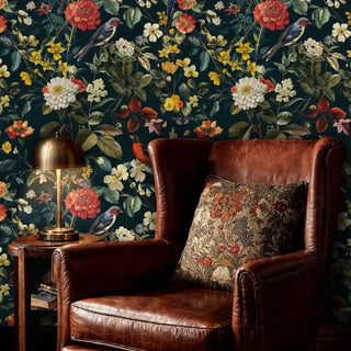 Botanical bird wallpaper with coral flowers on dark background, styled in study with brown leather armchair