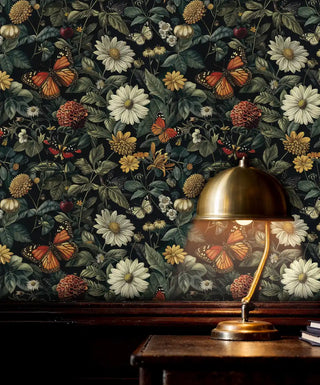 Botanical butterfly wallpaper featuring daisies and monarch butterflies with brass lamp on wooden desk