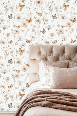 Botanical butterfly wallpaper with cream daisies and amber butterflies, displayed behind tufted beige headboard