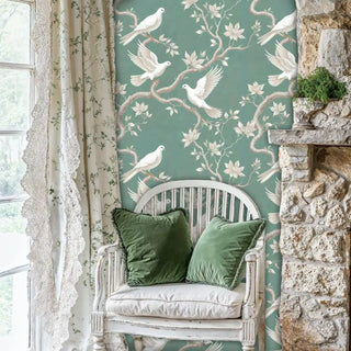 Botanical dove wallpaper with flowing branches and birds, shown in cozy corner with white vintage chair