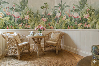 Botanical flamingo wallpaper featuring coral birds and lush foliage, shown in boho living room with rattan furniture