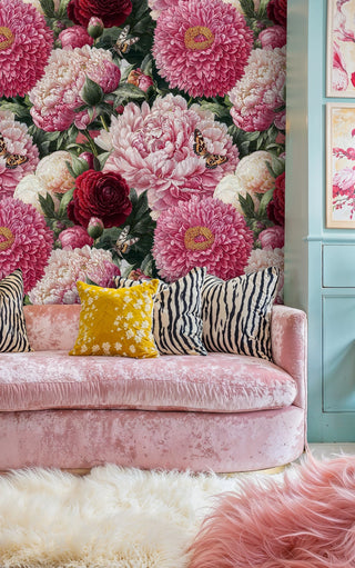 Botanical floral wallpaper with rich colors in stylish sitting area with pink velvet sofa and zebra pillows