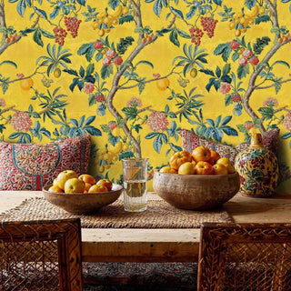 Botanical fruit tree wallpaper featuring grapes and tropical foliage, in dining room with ornate red chairs