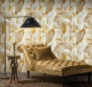 Botanical leaf wallpaper in gold and cream, displayed in sophisticated lounge with tufted velvet chaise