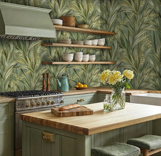 Botanical palm wallpaper in modern kitchen with sage green cabinets and wooden shelves