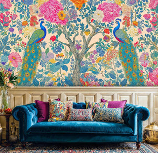 Botanical peacock wall mural featuring detailed birds and flowers, displayed in maximalist living room with blue velvet sofa