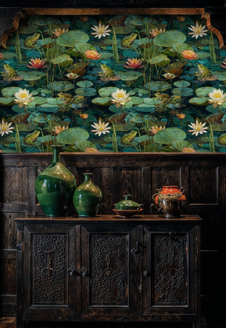 Botanical pond wallpaper featuring lily pads and water lilies in teal waters, shown above ornate wooden sideboard