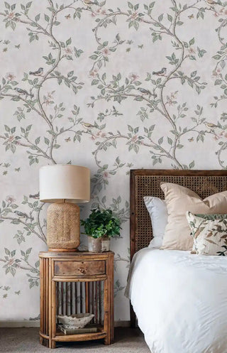 Botanical songbird wallpaper featuring branches with flowers and leaves, displayed in bedroom with woven lamp and bamboo nightstand