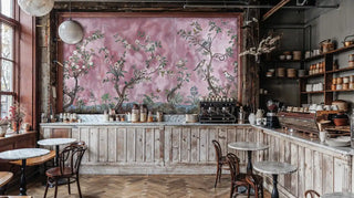 Botanical wall mural featuring birds and white blossoms on pink background, displayed in rustic cafe interior