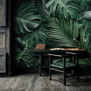 Botanical wall mural with detailed monstera and fern leaves in forest greens, shown in vintage study with antique desk