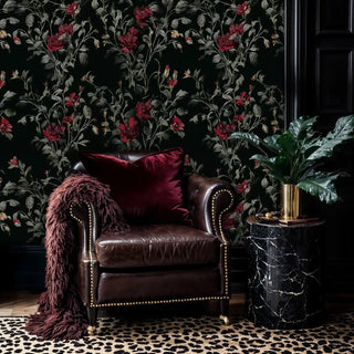 Botanical wallpaper featuring red flowers on black background in study with leather armchair and marble table