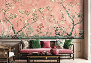 Botanical wallpaper featuring songbirds in flowering trees shown in elegant living room with coral cushions