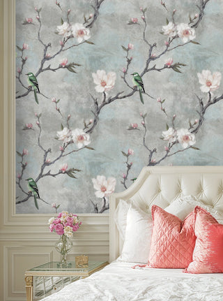 Botanical wallpaper featuring white magnolias and birds in sophisticated bedroom with tufted headboard