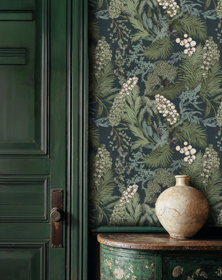 Botanical wallpaper with berry motifs and palm fronds displayed in entryway with vintage cabinet and ceramic vase