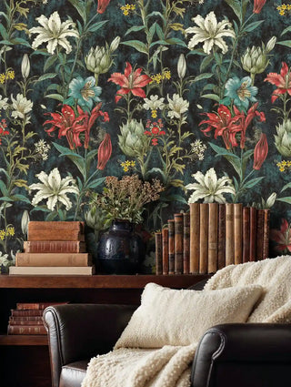 Botanical wallpaper with coral lilies in cozy reading nook with vintage books and cream throw