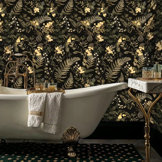 Botanical wallpaper with golden flowers and pine cones on black, shown in elegant bathroom with clawfoot tub