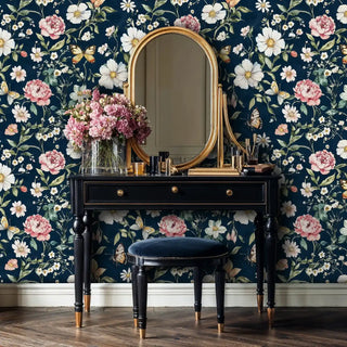 Botanical wallpaper with peonies and butterflies on navy background, shown in elegant vanity area with gold mirror