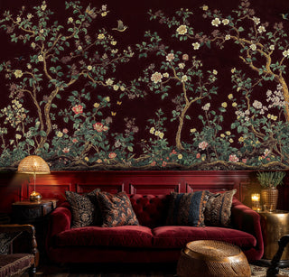 Burgundy chinoiserie wallpaper with golden branches and florals in sophisticated living room with red velvet sofa