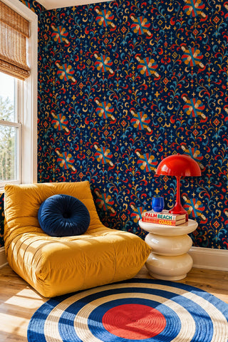 Celestial angel pattern wallpaper in navy with gold stars, in a reading nook with mustard lounger