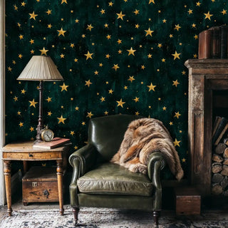 Celestial star wallpaper in emerald and gold, shown in cozy reading nook with fur throw