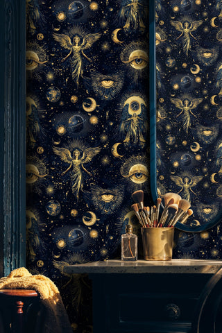 Celestial wallpaper with golden angels and cosmic eyes on navy blue, shown in elegant bathroom with vanity