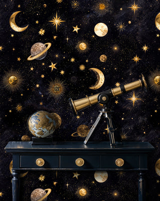 Celestial wallpaper with golden stars, moons, and planets on dark background, displayed in study with vintage telescope