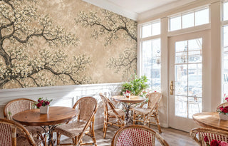 Cherry blossom tree mural with aged patina background, shown in a sunlit cafe with rattan bistro chairs and wainscoting