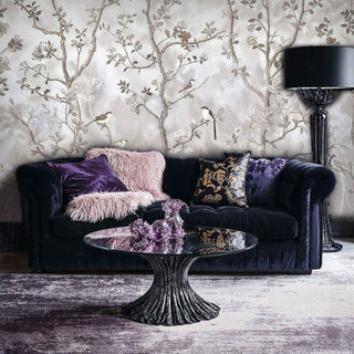 Chinoiserie botanical mural with songbirds, displayed behind luxurious purple velvet sofa