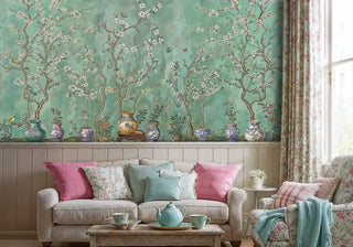 Chinoiserie floral wallpaper with jade background and pink blossoms, shown in cottage living room with floral cushions