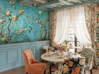 Chinoiserie garden wallpaper showing flowering branches and butterflies, in cozy tea room with floral curtains