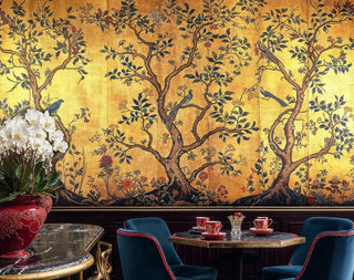 Chinoiserie Wall Mural with golden birds and flowering trees in elegant dining room with blue chairs and marble table
