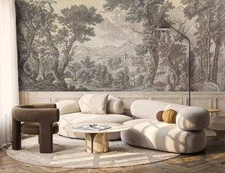 Classical landscape wall mural with gnarled trees and pastoral figures, shown in modern living room with curved sofa