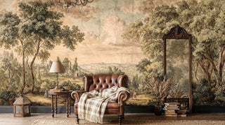 Classical landscape wall mural with rolling hills, shown in cozy reading nook with leather armchair