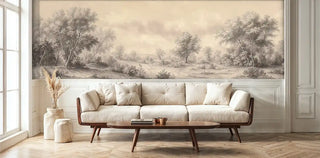 Classical landscape wall mural with sepia trees and rolling hills in beige tones, shown in modern living room with cream sofa