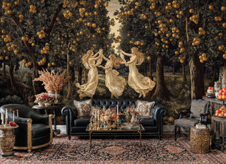 Classical muses in golden orchard wallpaper featuring three graceful dancers, displayed in opulent living room with black leather Chesterfield sofa and brass accents